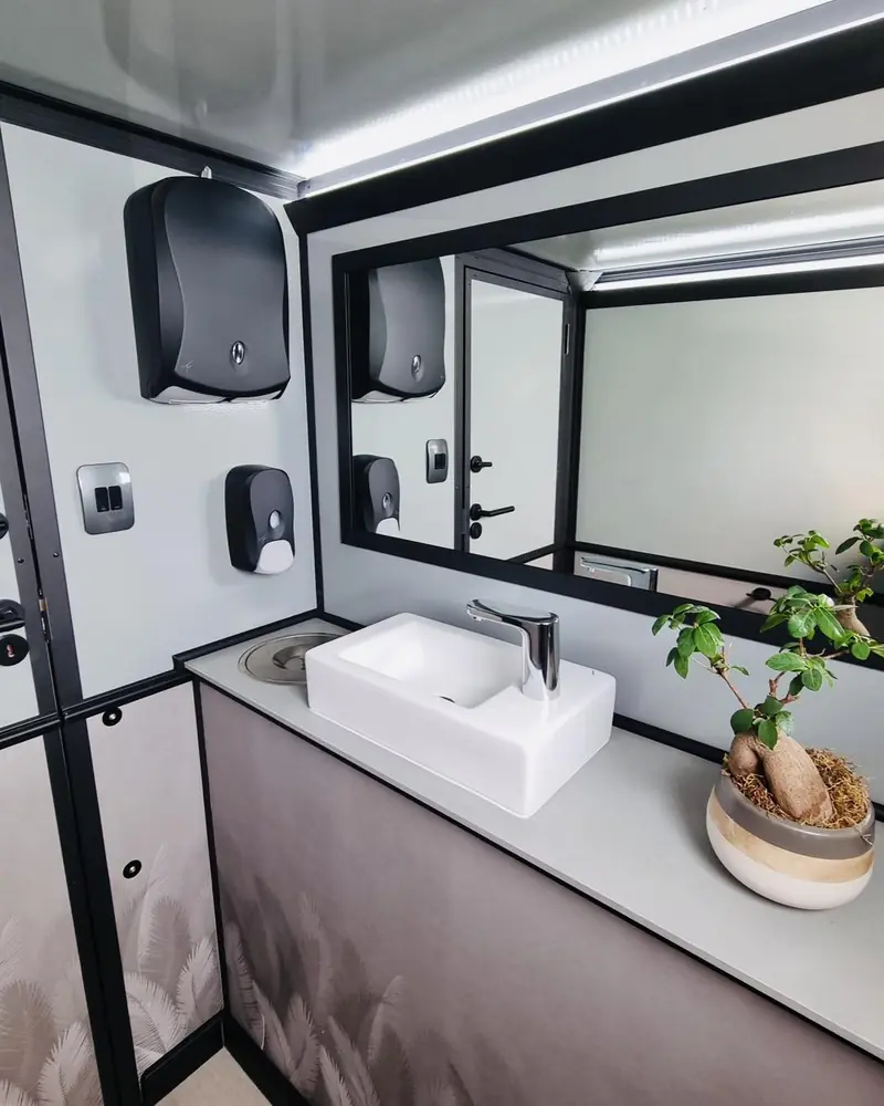 Restroom trailer vanity with vessel sink, soap and paper towel dispensers